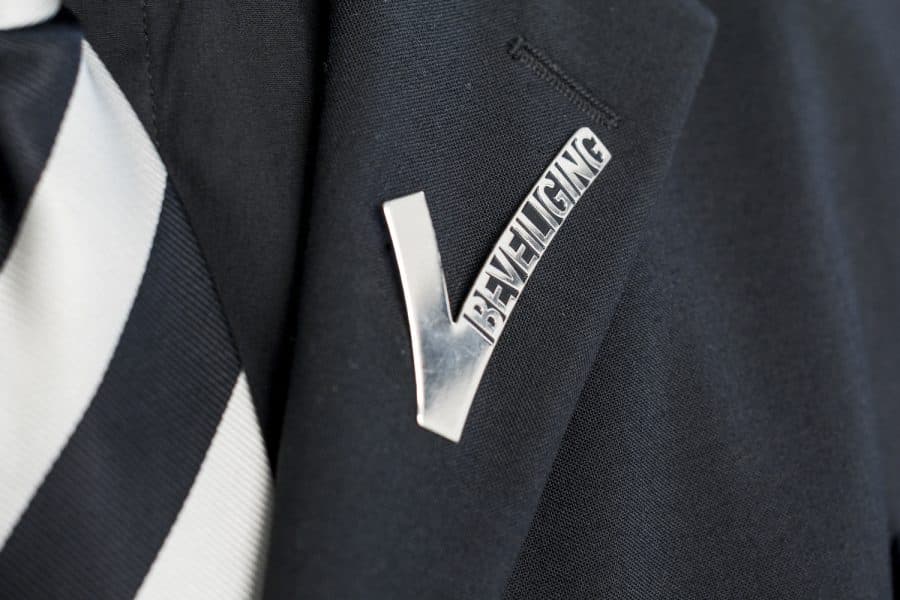 Detail van een beveiligingsuniform met het Nederlandse beveiligingsembleem